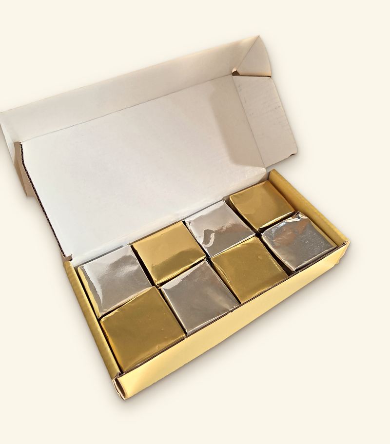 An open butter-yellow Butter Boy Fudge box holding 8 foil-wrapped fudge pieces, alternating gold and silver